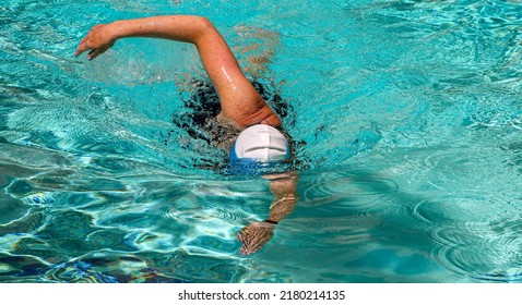 Close up of the front view of a women swimming freestyle laps in a hotel pool. - Shutterstock ID 2180214135