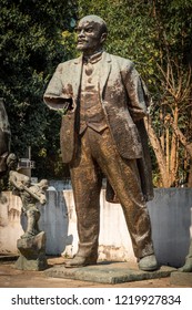 Close up front view of a worn broken bronze statue of Lenin in a city park in Tirana Albania.