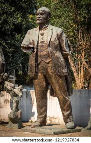 Close up front view of a worn broken bronze statue of Lenin in a city park in Tirana Albania.
