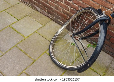 Close Up Of A Front Wheel Of A Black Bicycle Which Is Bent