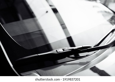 close up of front Windshield Wipers on a black new car in salon. selective focus.
