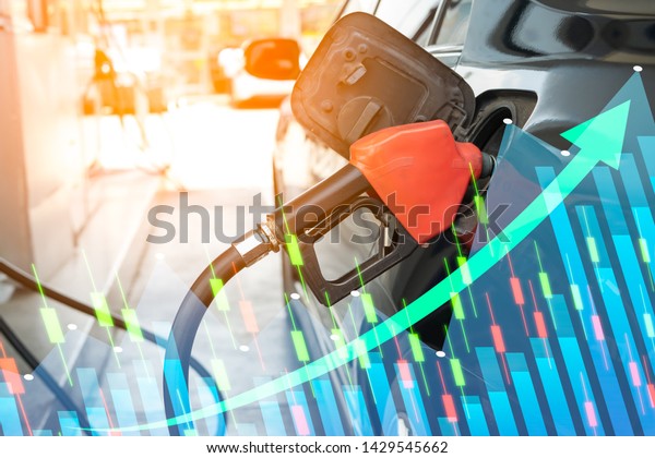 Close up of fuel monitoring system refueling a\
petroleum to vehicle and graph chart with the indicator on the oil\
price slide at gas station. Concept fluctuations in oil prices and\
exchange trade.