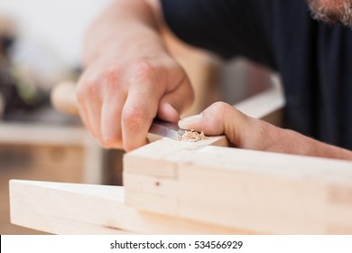 Close Up Of A Furniture Maker Chiselling A Chair Joint