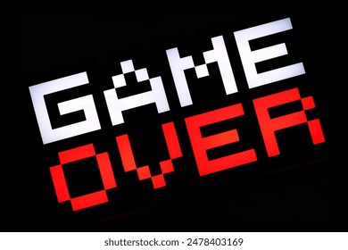 Close up of a Game Over 8-bit sign in an arcade - Powered by Shutterstock - Get 15% off with code: PIKWIZARD15
