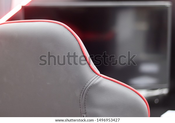 close up of a gaming chair.gray and red\
gaming chair in front of a computer desk\
