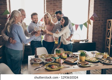 Close Up Of Gathered Relatives In Decorated House Dinner Table With Glasses Golden Beverage In Hands Family Best Friends Wishing All Great Big Large Company