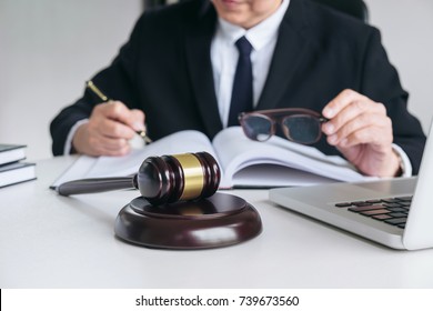 Close up of gavel, Male lawyer or judge working with Law books, report the case on table in modern office, Law and justice concept.