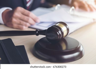 Close up of gavel, Male lawyer working with scales of justice, books, report the case on wooden table in office, Law and justice concept.