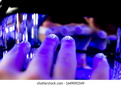 Close Up Of Gel Nail Polish On Short Nails Curing Under UV Light