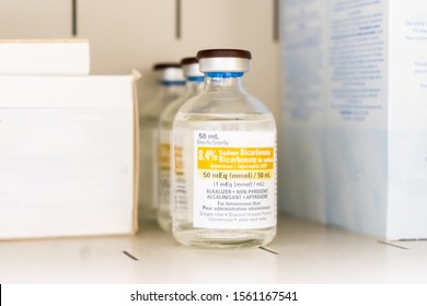 Close Up Of Generic 8.4% Sodium Bicarbonate Injection Used As An Alkalizer, Non-pyrogenic, For Intravenous Use, In A Single-use Vial. Sitting On A Shelf In A Doctor’s Medical Supply Closet.