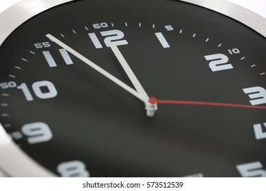 Close up to generic black and silver wall clock showing at the eleventh hour 