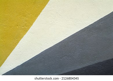 Close up of a geometric mural paint in an urban street, ethnic color palette on wall textured background.
