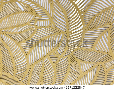 Close up of geometrical leaves shape pattern cutouts in metallic gold paint finish. 3D cutout laser cut foliage leaf shapes suitable for screens or divider. Seamless background texture.