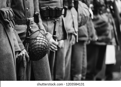 Close Up Of German Military Ammunition Of A German Soldier. Unidentified Re-enactors Dressed As World War II German Soldiers Standing Order. Photo In Black And White Colors. Soldiers Holding Weapon 