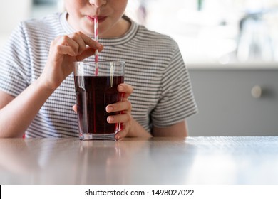 Close Up Of Girl Drinking Sugary Fizzy Soda From Glass With Straw