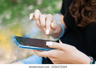 Close up girl with long nails typing in phone, blurred russian letter  - Powered by Shutterstock