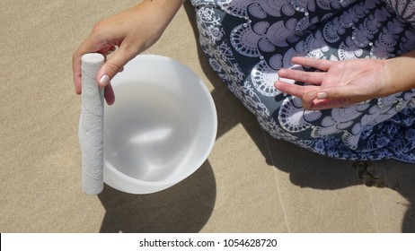 Close Up Of Girl Playing Crystal Sound Bowl