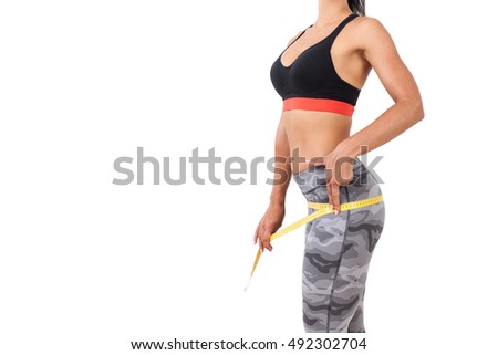 Close up of girl in sport clothes who is measuring her hips. Concept of staying fit and healthy. Mock up