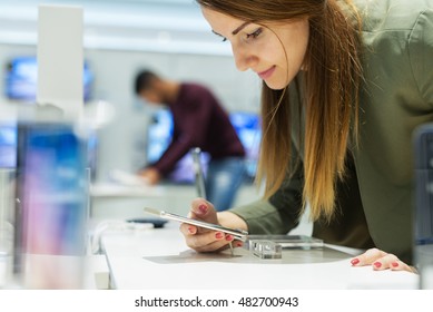 Close Up Of A Girl In A Tech Store, Exploring New Smart Phone.