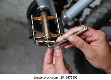 Close up of girl using hex wrench key on bike pedal