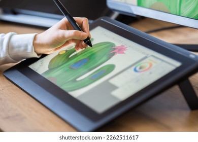 close up of a girls hand drawing on a digital tablet. drawing on a digital drawing board. Graphic designer working from home