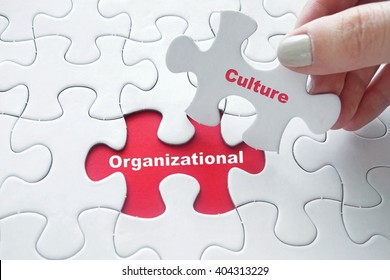 Close up of girl's hand placing the last jigsaw puzzle piece with word Organizational Culture - Shutterstock ID 404313229