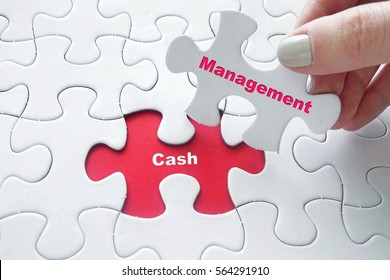 Close Up Of Girl's Hand Placing The Last Jigsaw Puzzle Piece With Word Cash Management