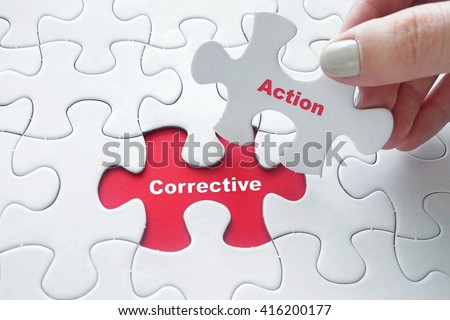 Close up of girl's hand placing the last jigsaw puzzle piece with word Corrective Action