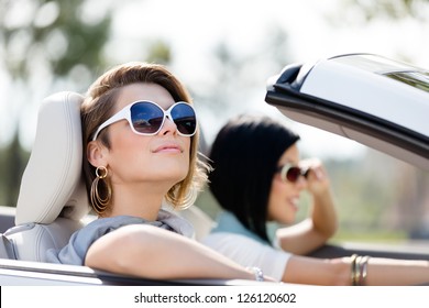 Close up of girls wearing sunglasses in the white car. Little holiday trip of friends - Powered by Shutterstock