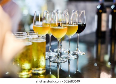 Close up of a glass of beer, wine and champagne in a bar. Many glasses of different alcohol drink in a row on bar counter. Select focus.