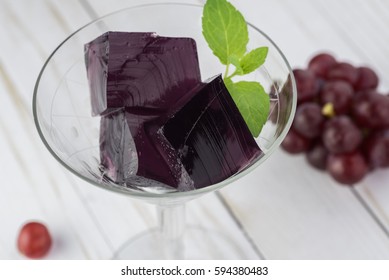 Close up of glass with crape vodka cocktail jello cubes.