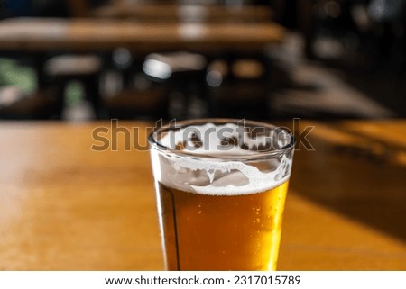 Close up of a glass of draft larger beer with foam