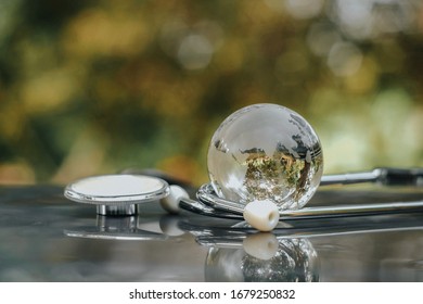 Close up glass global and stethoscope on table, world health day, medical and healthcare, life insurance business technology, 2019-ncov risk and problem, coronavirus covid-19 warning concept