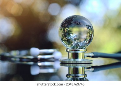 Close Up Glass Globe And Stethoscope On Table, World Health Day, Medical And Healthcare, Telemedicine And Climate Change, Global Pandemic Crisis Risk And Problem Concept