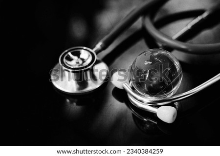 close up glass globe and stethoscope on table, world health day, medical and healthcare, life insurance business technology, world environment day and climate change crisis risk and problem concept