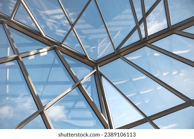 Close up of a glass roof with blue sky in the background - Powered by Shutterstock