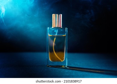 Close Up Of Glass Transparent Bottle Of Male Perfume On Dark Background With Smoke. Perfumes And Cosmetics Concept.