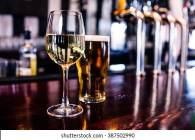 Close up of a glass of wine and a beer in a bar