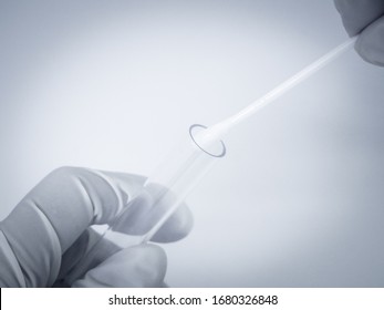 Close up of gloved hand placing holding Taking Saliva Test With Cotton Swab , in to Test tubes  - Shutterstock ID 1680326848