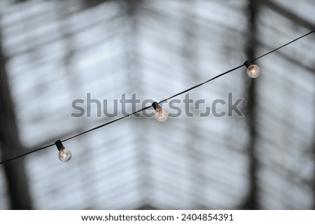 close up of glowing string lights with defocus glass roof background 