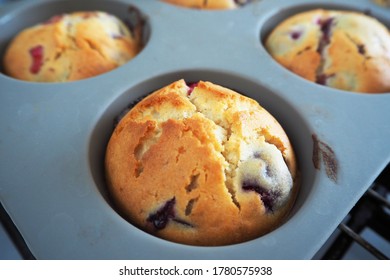 Close Gluten-free Rice And Corn Flour Muffin With Cherries In A Gray Silicone Mold Only From The Oven Side View . Homemade Cake