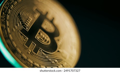 Close up of gold bitcoin coin spinning on the dark blue background. Digital cryptocurrency virtual money. Blockchain modern technology. P2P bitcoin trading. Peer-to-peer payment system. BTC logo.