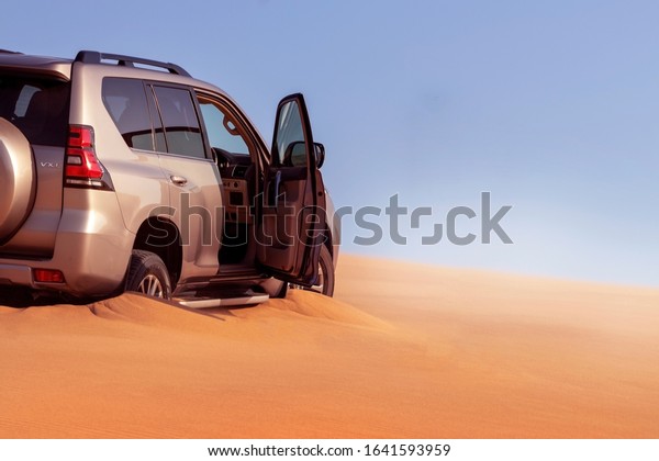 Close up of a golden car\
stuck in the sand in the Namib desert. Walvis Bay. Namibia. Africa\
07.02.2020