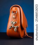 Close up of golden  dog ​​shaped keychain on trendy brown  bag