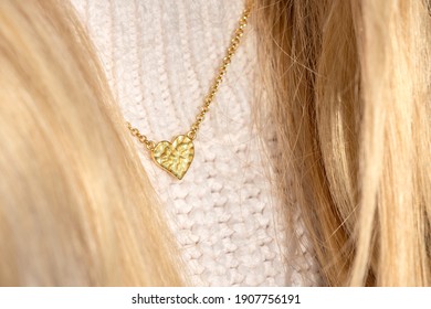 Close up Golden heart Necklace on neck with blond hair. Detail of a Beautiful Necklace in Glamour Shot with caucasian blond model.