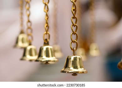Close up golden jingle bells hanging in a row with golden chain, one thing important for seasonal decorating; Merry Christmas, Happy new year