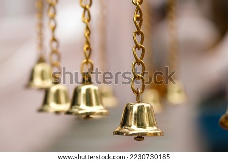 Close up golden jingle bells hanging in a row with golden chain, one thing important for seasonal decorating; Merry Christmas, Happy new year