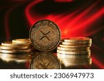Close up of golden Ripple XRP cryptocurrency with red abstract background