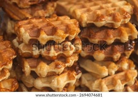 Close up of golden Liège waffle stack with caramelized sugar and rich texture, traditional Belgian sweet treat for breakfast or dessert.