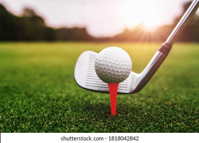 Close Up Golf Club And Golf Ball On Green Grass With Sunrise Background